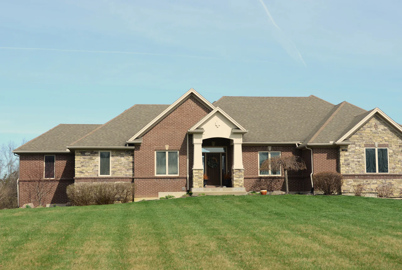Brick home with a mowed front lawn on a bright day